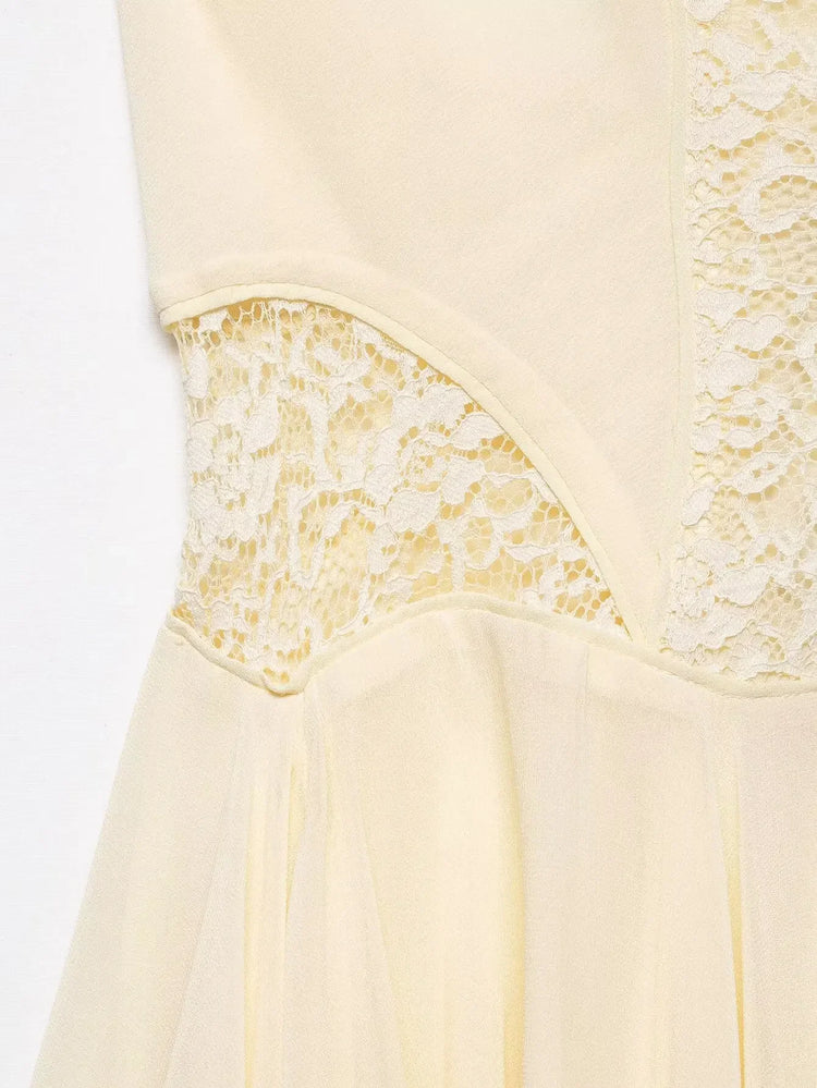 Close-up of a beige dress with lace detailing on a white background