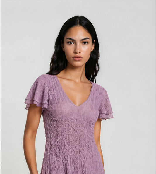 Woman wearing a purple dress against a plain background