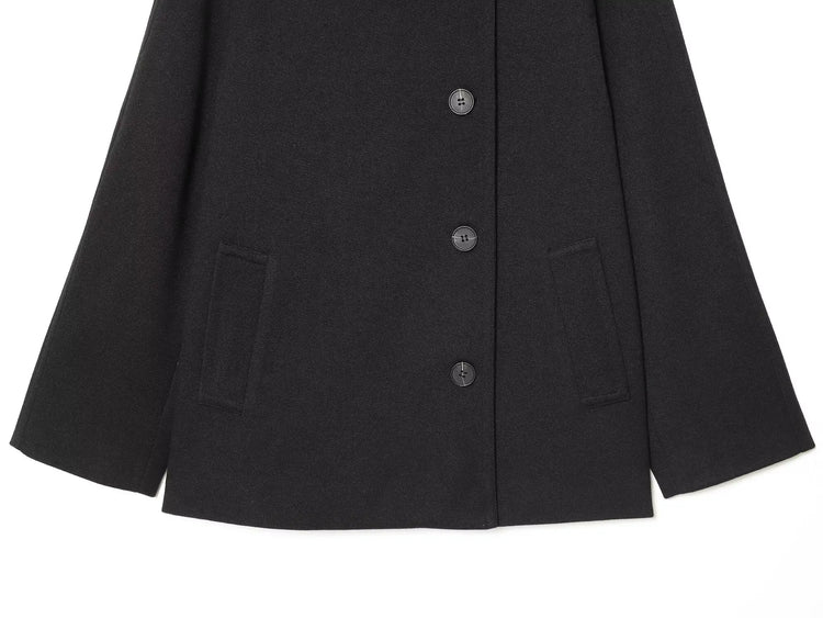 Black women's coat with buttons for Spring on a white background close up of bottom