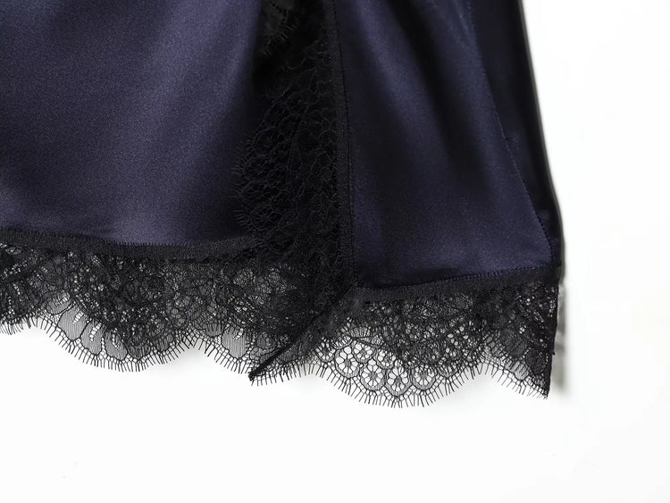 Navy blue dress close up with black lace trim on a white background