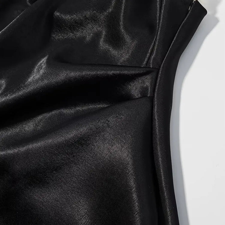 Close-up of black satin fabric with folds on a white background