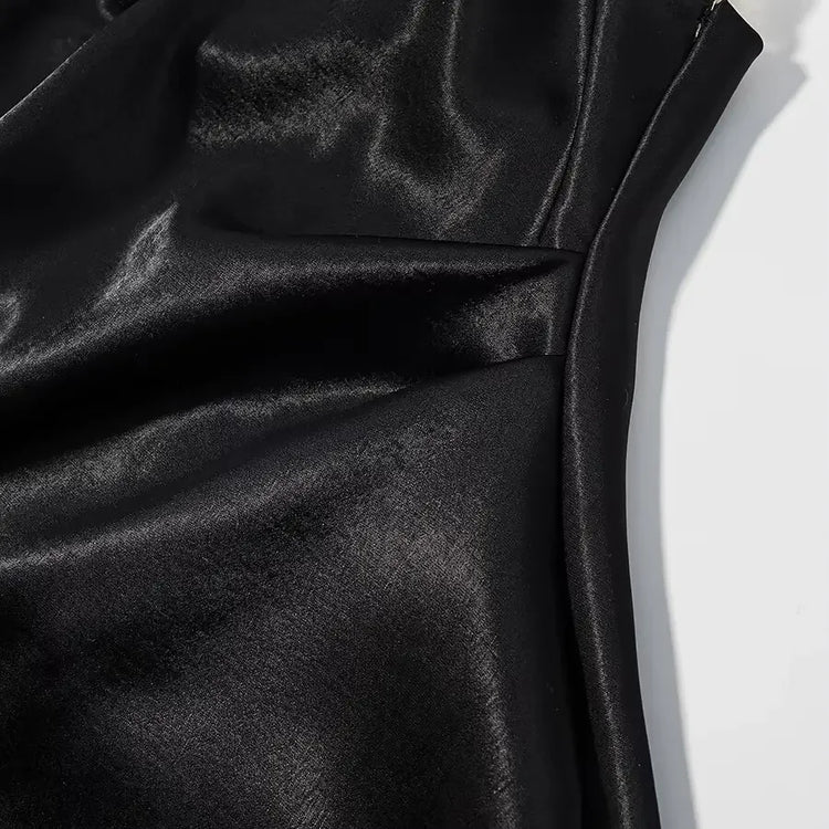 Close-up of black satin fabric with folds on a white background
