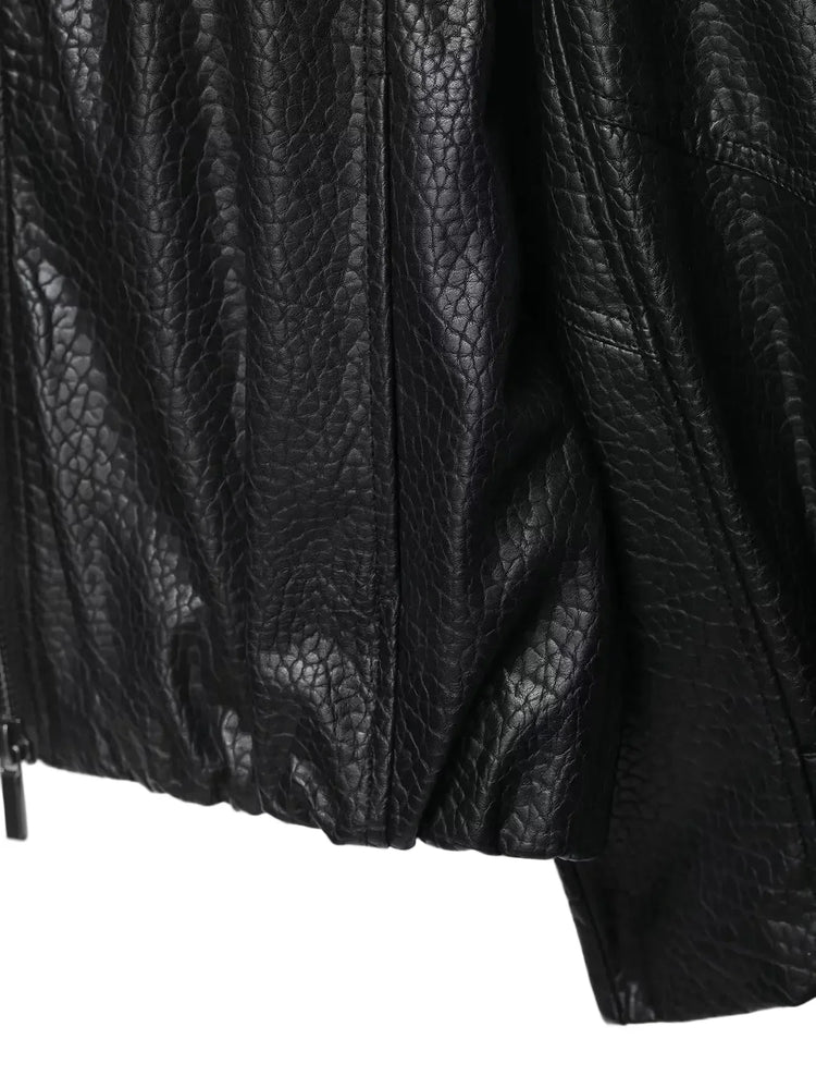 Close-up of a textured black leather jacket on a white background