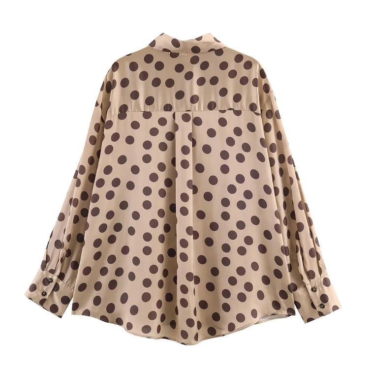 Beige blouse with brown polka dot pattern on a white background