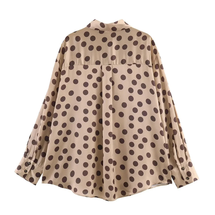 Beige blouse with brown polka dot pattern on a white background