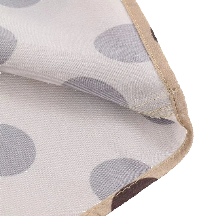 Close-up of a fabric with gray polka dots and a beige border on a white background