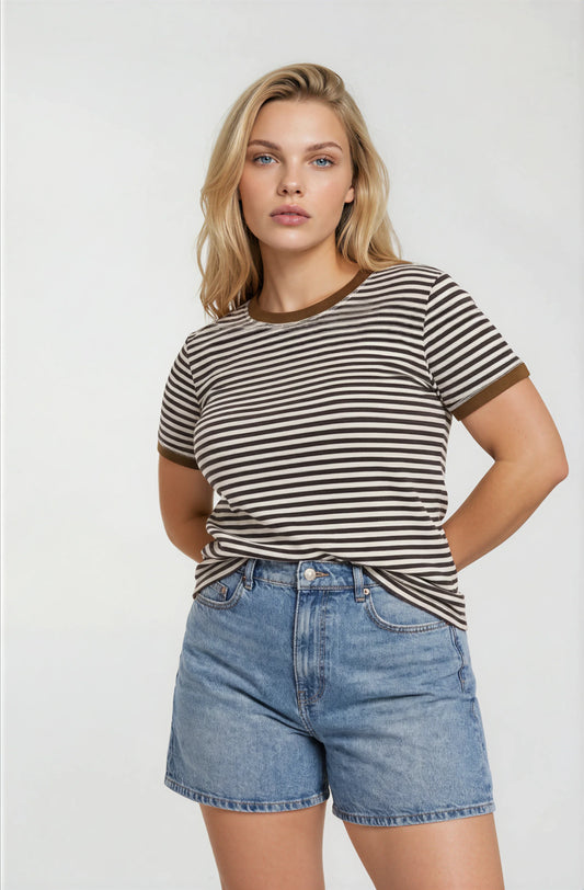 Woman wearing a brown striped short sleeve t-shirt and denim shorts on a white background