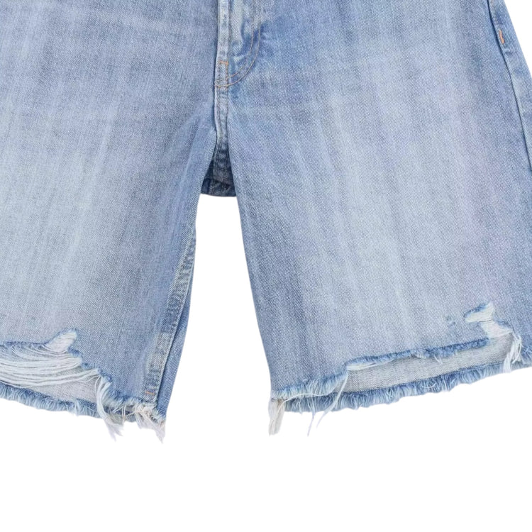 Close-up of light blue denim shorts with frayed edges on a white background