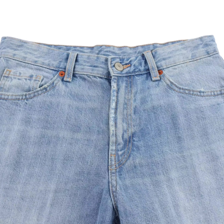 Close-up of light blue denim jeans on a white background