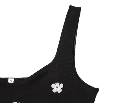 Black women's sleeveless dress with white floral patterns for Spring on a white background close up of shoulder strap