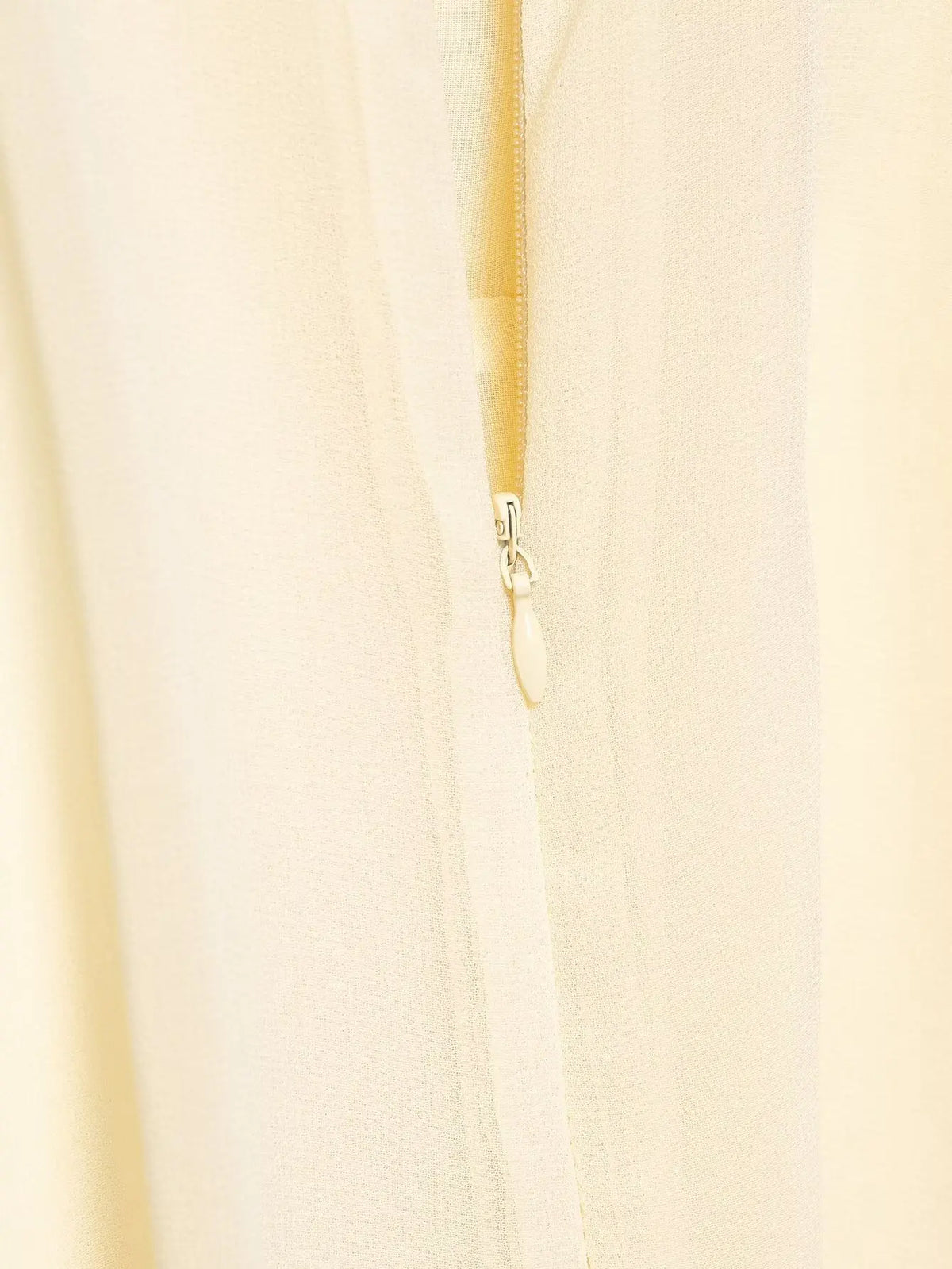 Close-up of a beige zipper on a light background