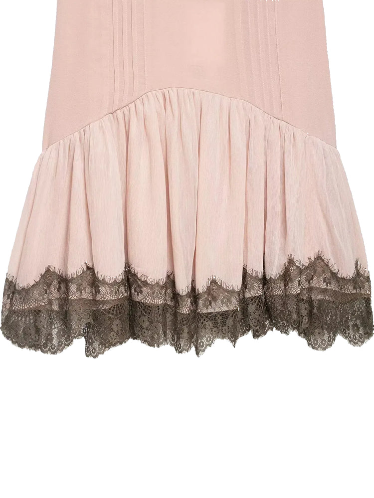 Close-up of a pink dress with lace trim on a white background