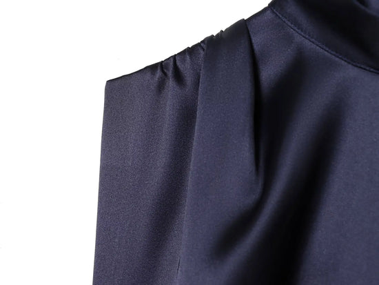 Navy blue dress close up with a pleated texture on a white background