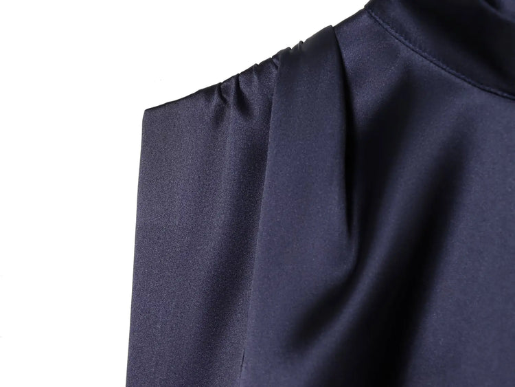 Navy blue dress close up with a pleated texture on a white background
