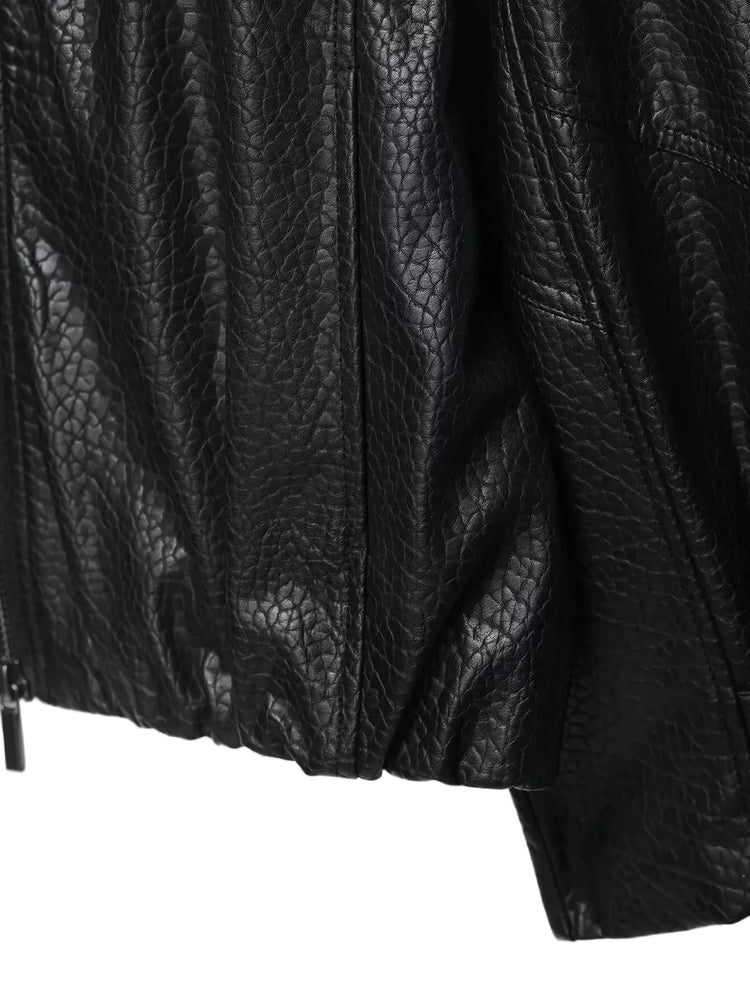 Close-up of a textured black leather jacket on a white background