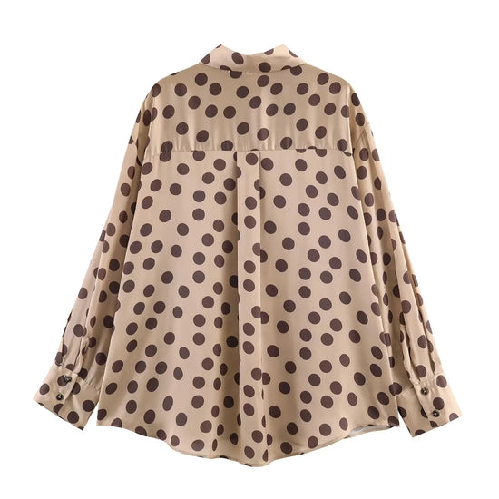 Beige blouse with brown polka dot pattern on a white background