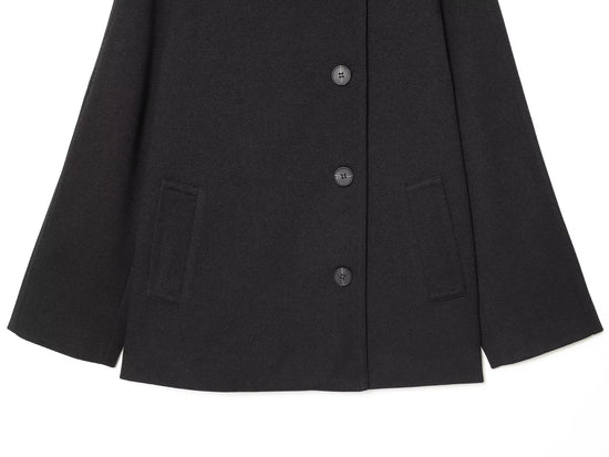 Black women's coat with buttons for Spring on a white background close up of bottom