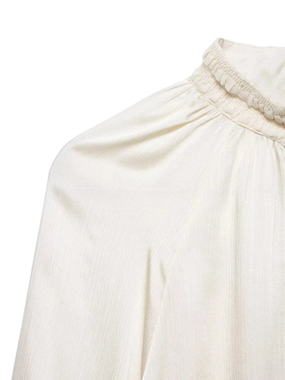 Close-up of a cream-colored garment with a white background