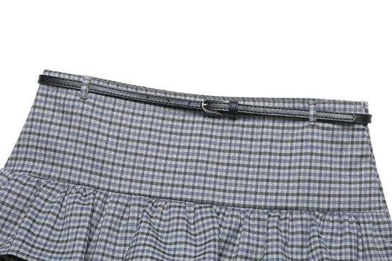 close up of plaid spring skirt with a black belt on a white background