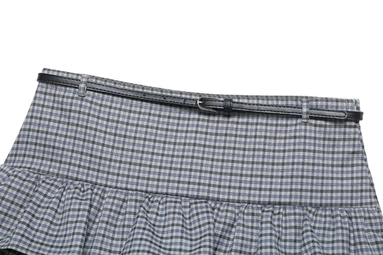 close up of plaid spring skirt with a black belt on a white background